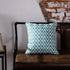 Blue and white chevron throw pillow on rustic leather bench against exposed brick wall