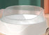 White pet water bowl with transparent splash guard on a tabletop
