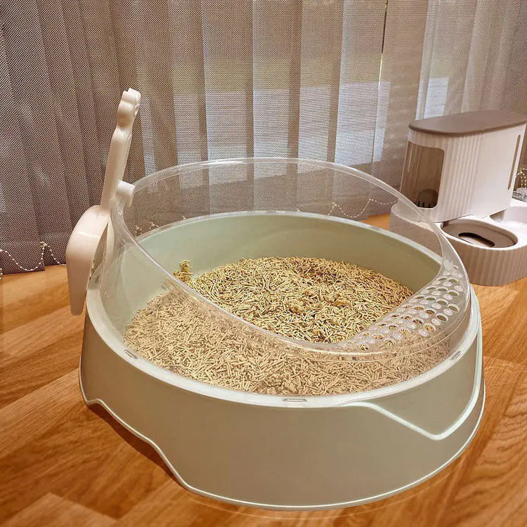 Enclosed cat litter box with transparent shield on wood floor near pet feeder
