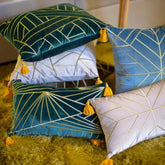 Velvet throw pillows with gold geometric patterns and yellow tassels on a shaggy rug