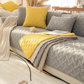 Modern living room with a beige sofa, yellow and gray geometric throw pillows and blankets