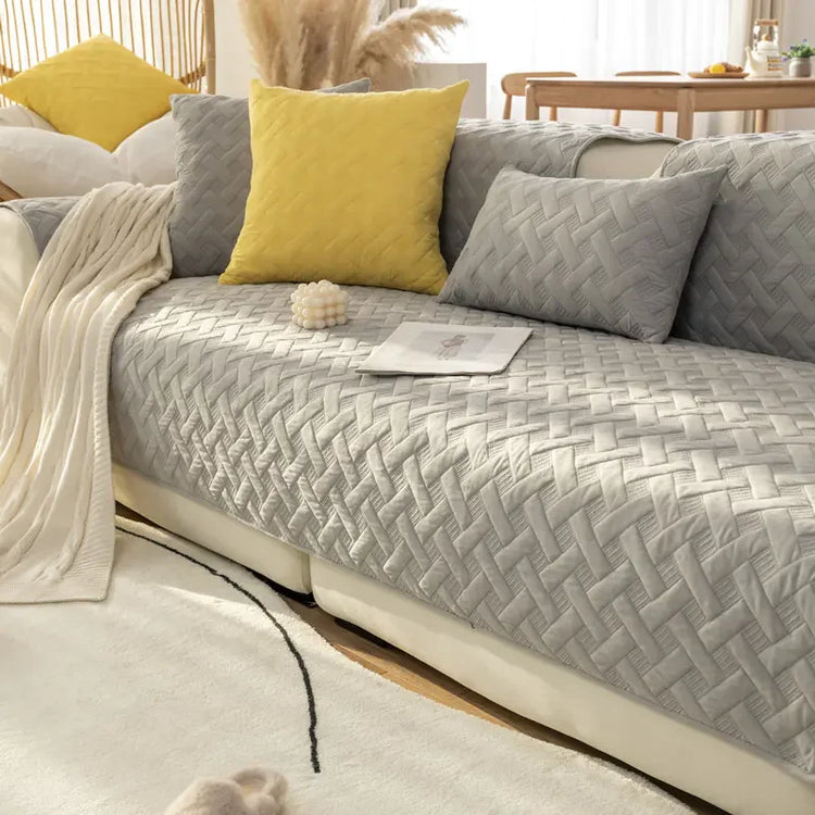 Modern living room with a grey textured sofa cover, yellow and grey pillows, cozy throw blanket