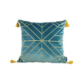 Blue velvet throw pillow with gold geometric lines and yellow tassels on each corner