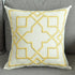 Cream decorative throw pillow with yellow geometric pattern on gray sofa