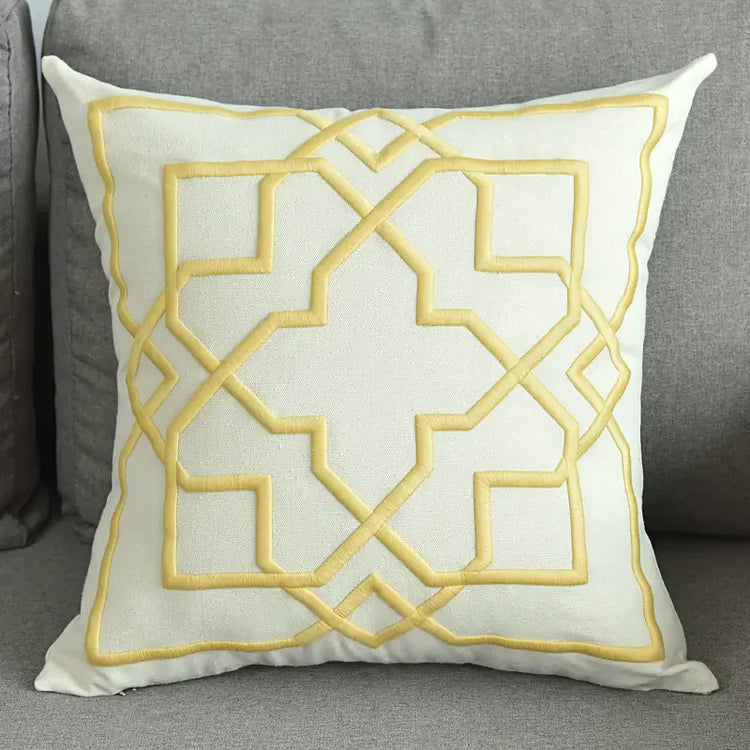 Cream decorative throw pillow with yellow geometric pattern on gray sofa