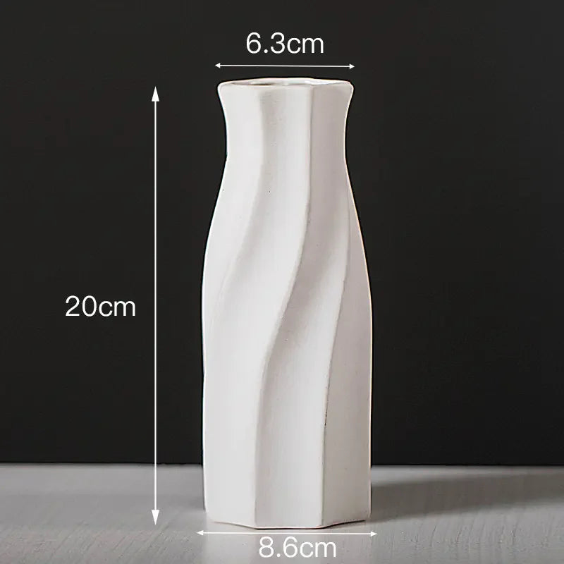 White ceramic vase with twisted design, 20cm tall, 6.3cm top, 8.6cm base, on grey surface