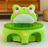 Plush green frog baby chair with crown design in a cozy room setting