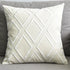 White decorative throw pillow with diamond pattern on a grey sofa