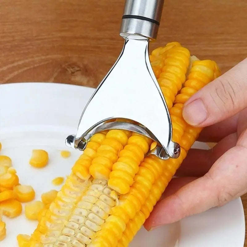 Corn peeler tool removing kernels from ear of corn on white plate