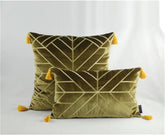 Olive green velvet cushions with geometric patterns and yellow tassel accents