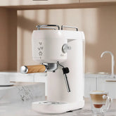 Modern white espresso machine with wood accents on marble kitchen counter, latte nearby